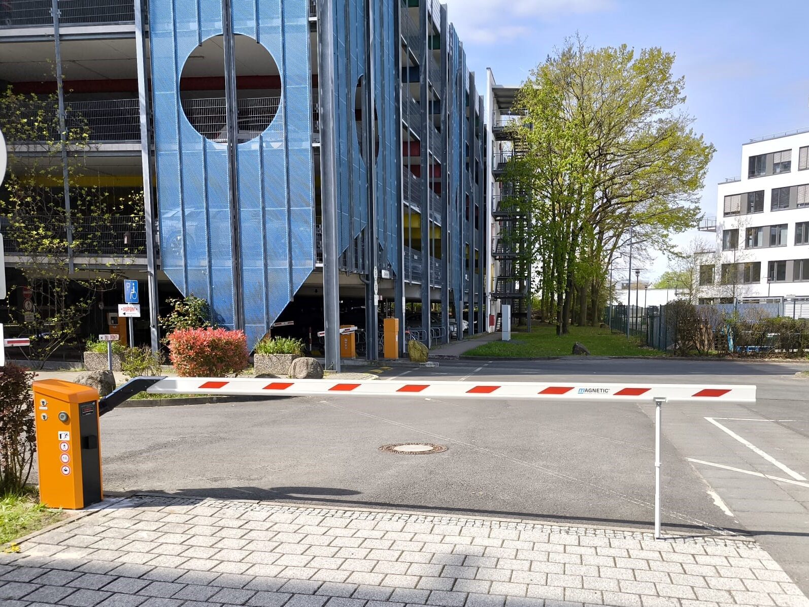 Geschlossene Schranke vor einem blau verspiegelten Bürogebäude