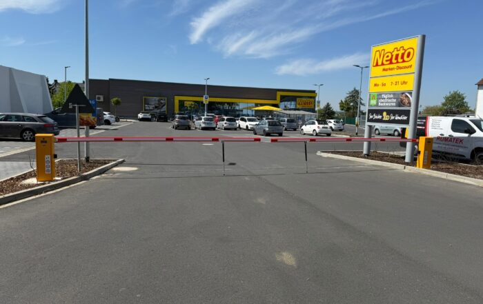 Rot-weiße Schranke vor dem Parkplatz eines Supermarkt Discounters