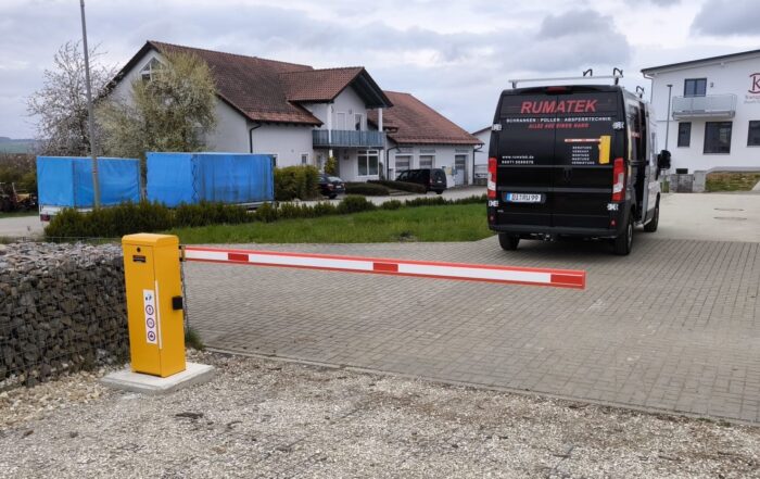 Automatische Schranke vor einem Kleintransporter mit Aufschrift