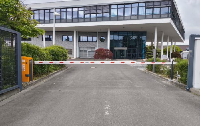 Automatische Schranke vor einem modernen verglasten Bürogebäude