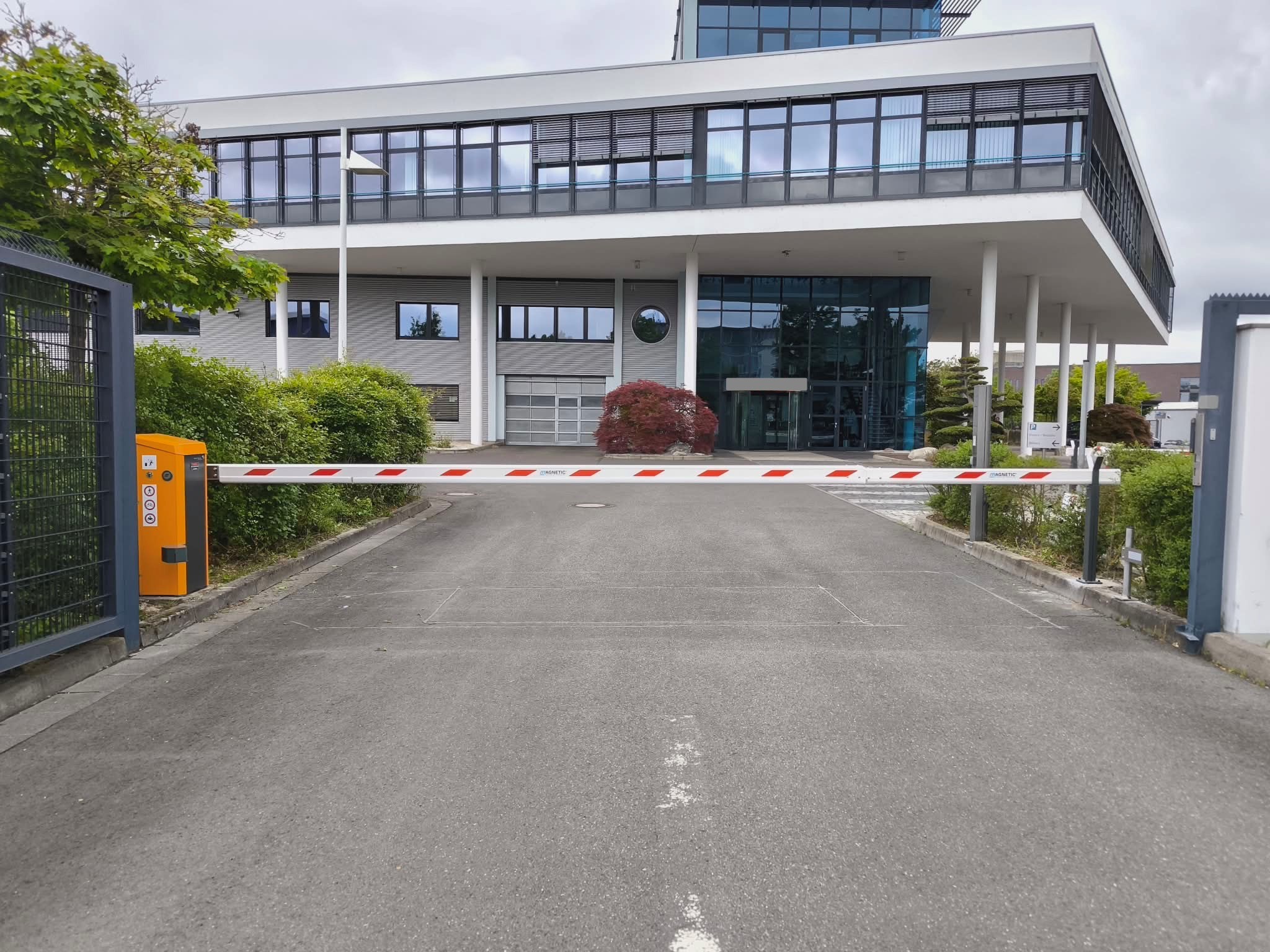 Automatische Schranke vor einem modernen verglasten Bürogebäude