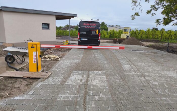 Automatische Schranke vor einem schwarzen Transporter