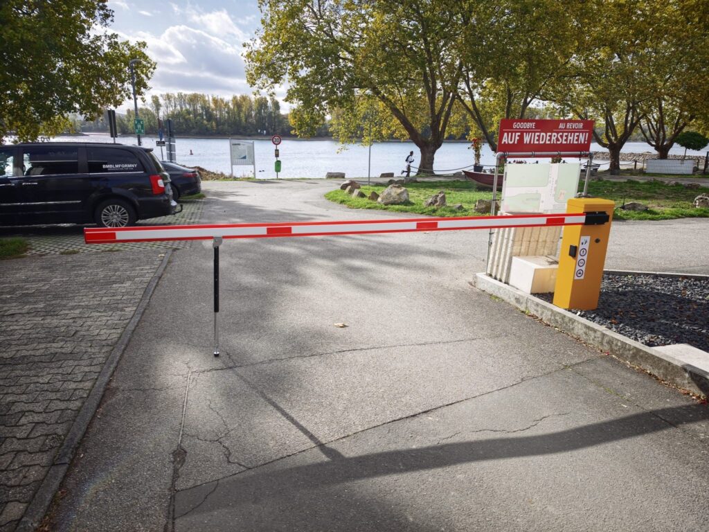 Schranke an der Zufahrt zu einem Campingplatz, dahinter ein Fluss
